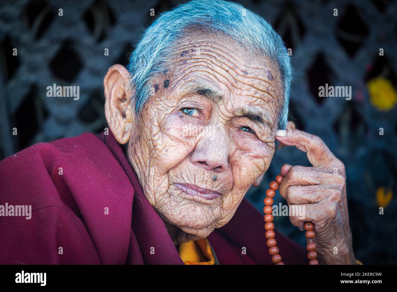 Elderly female Buddhist nun at Boudhanath stupa, Boudhanath, Kathmandu, Nepal Stock Photo