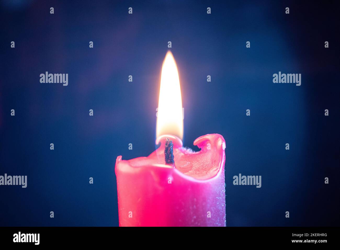Candle flame flickers in the wind against a black background Stock Photo