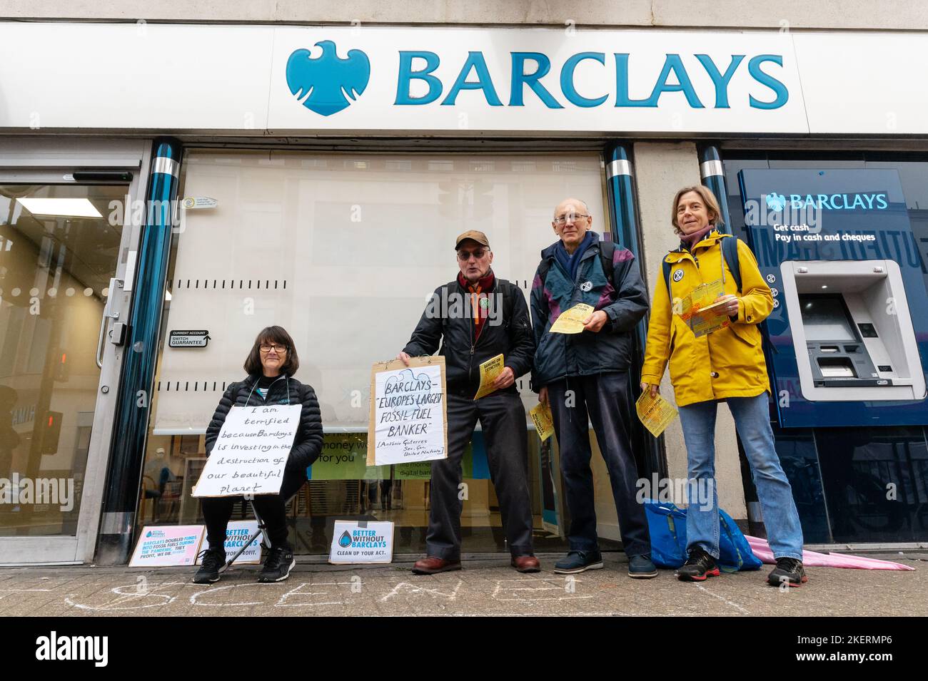 London, UK. 14 November 2022. Climate activists from Extinction Rebellion and Money Rebellion protest outside Barclays branch in Tooting, south London, in a UK wide campaign called 'Better without Barclays. Protesters are holding a placard that denounce Barclays investing in fossil fuels. Credit: Andrea Domeniconi/Alamy Live News Stock Photo