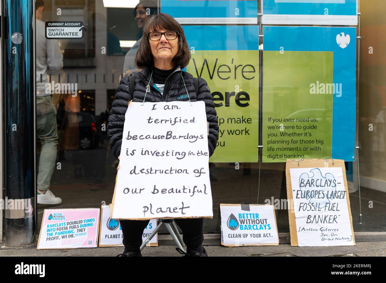 London, UK. 14 November 2022. Climate activists from Extinction Rebellion and Money Rebellion protest outside Barclays branch in Tooting, south London, in a UK wide campaign called 'Better without Barclays. Protesters are holding a placard that denounce Barclays investing in fossil fuels. Credit: Andrea Domeniconi/Alamy Live News Stock Photo