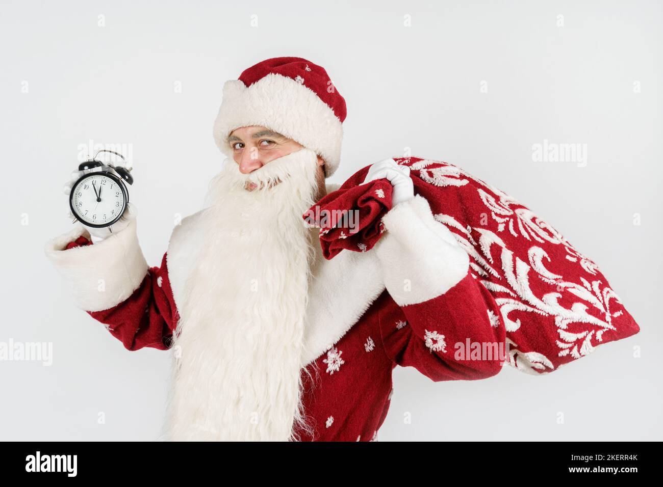 Holidays and Christmas concepts. Santa Claus shows the time remaining before Christmas on the clock. Isolated on white Stock Photo