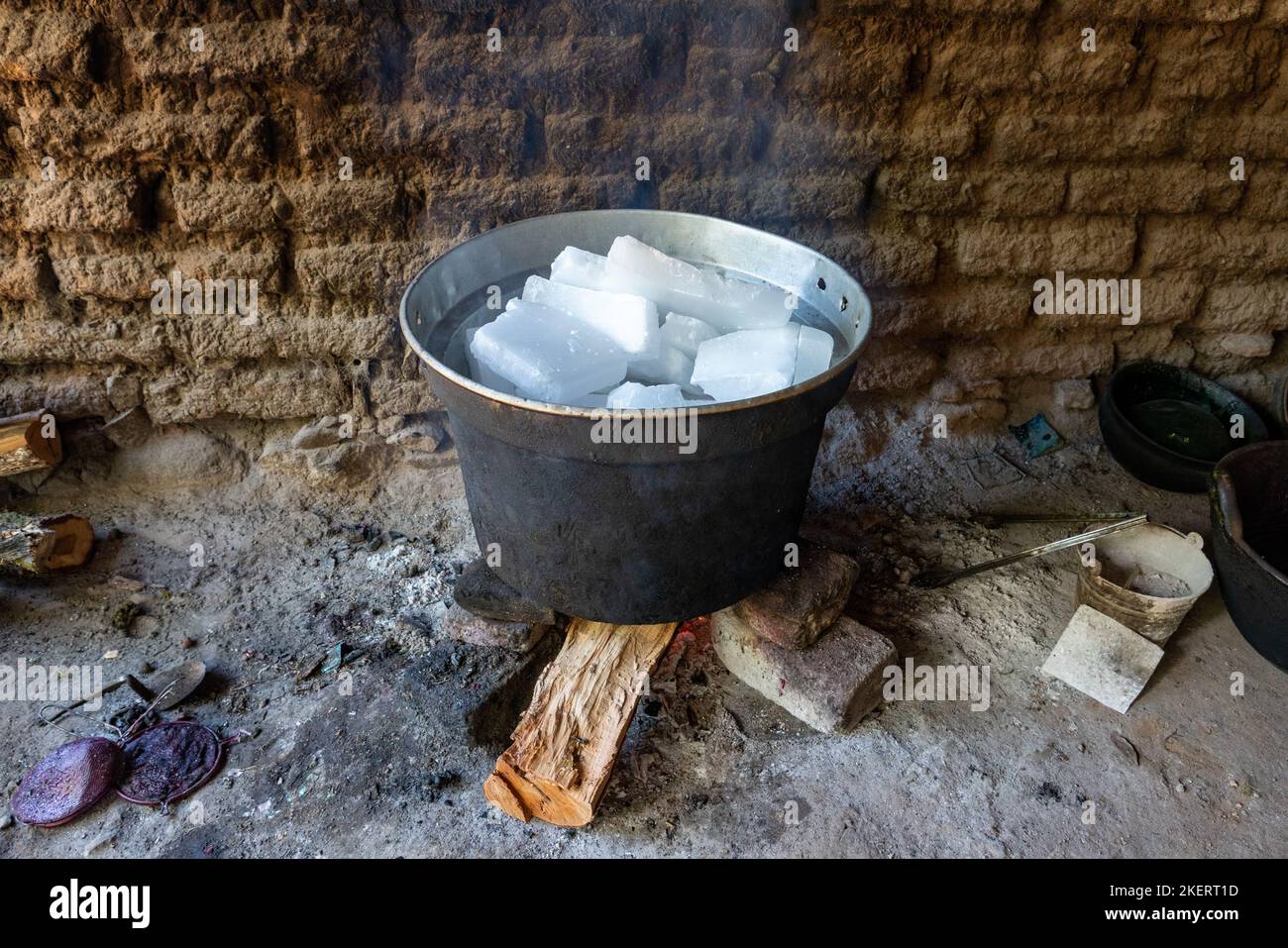 Melting paraffin wax over a wood fire for making candles in the Casa