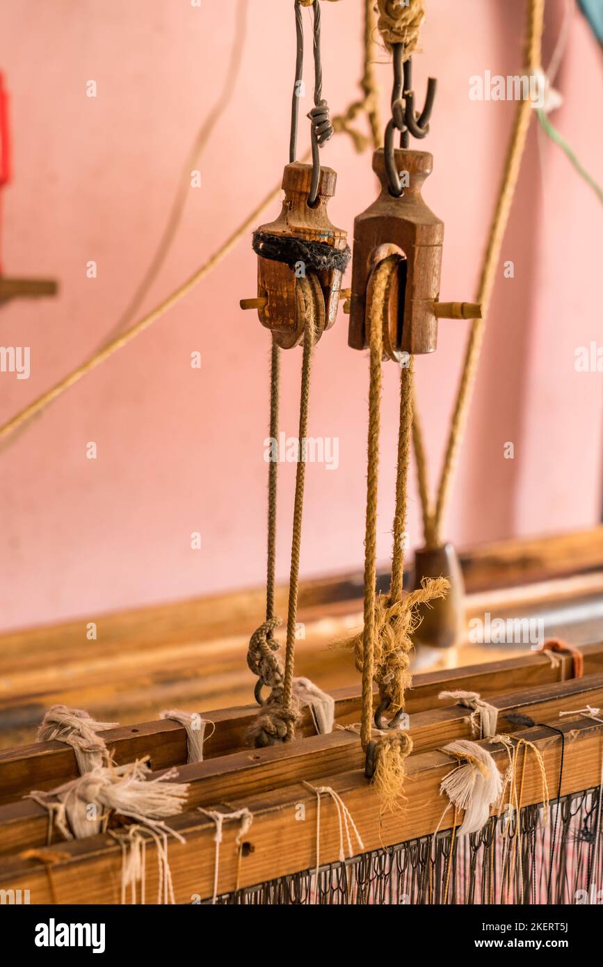 Detail of pulleys on a large wooden foot treadle loom in a home