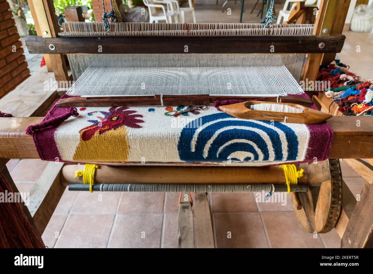 Woolen rugs made with natural dyes being woven on wooden foottreadle