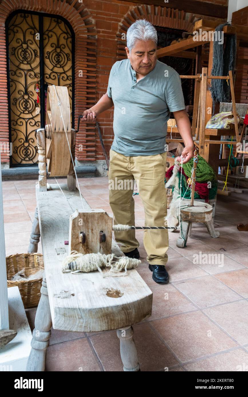 Master weaver Jeronimo Vazquez G. demonstrates how the wool is spun by hand into yarn for weaving rugs.  Teiotitlan del Valle, Oaxaca, Mexico. Stock Photo