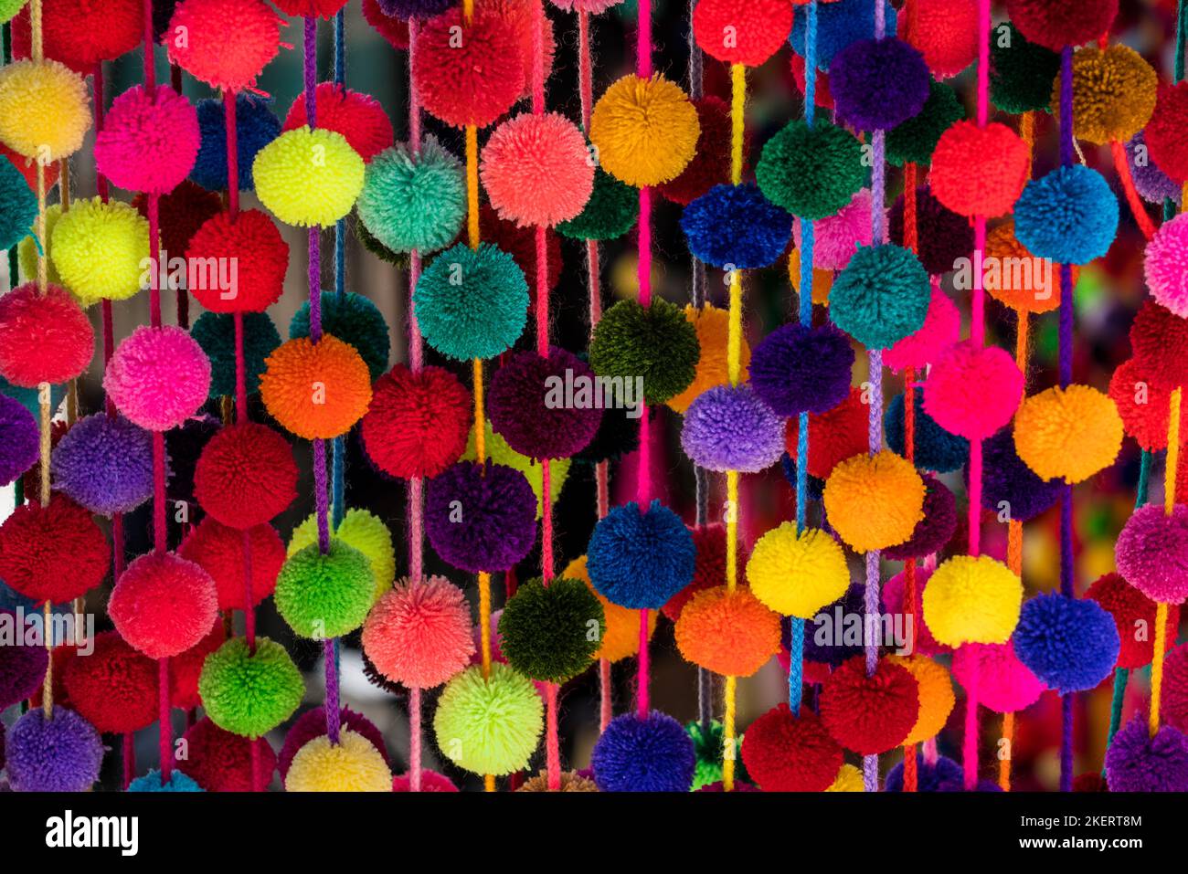 Colorful decorative pom poms for sale at a street market in Oaxaca