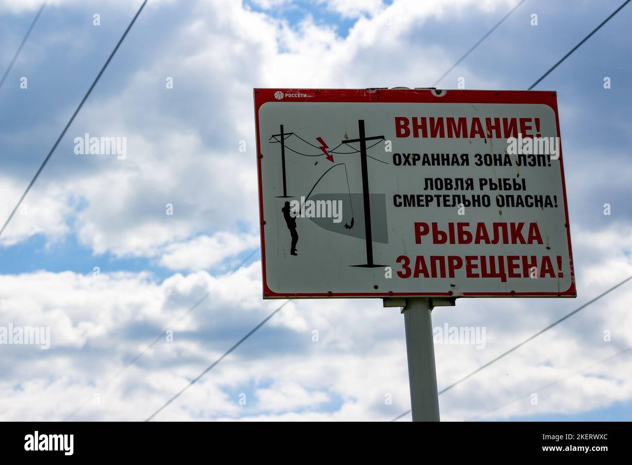 Information plate with the inscription Attention! Power line security zone! Fishing is deadly! Fishing is not allowed here! Russia - June 2021 Stock Photo