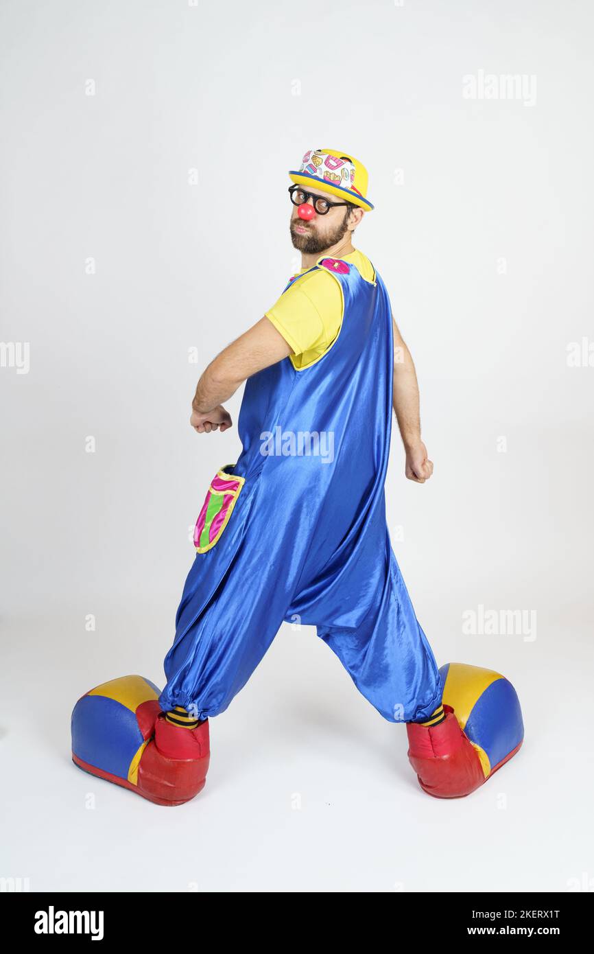 Holiday concept. The clown is a man in a bright blue and yellow suit ...