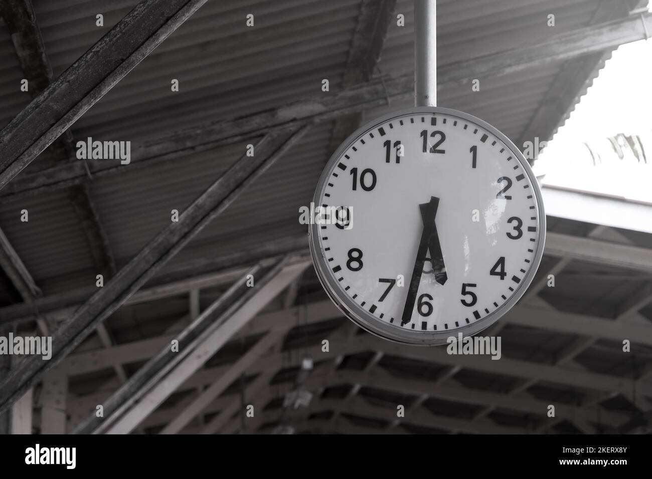 A white vintage round clock hanging on the roof of a train station. Stock Photo
