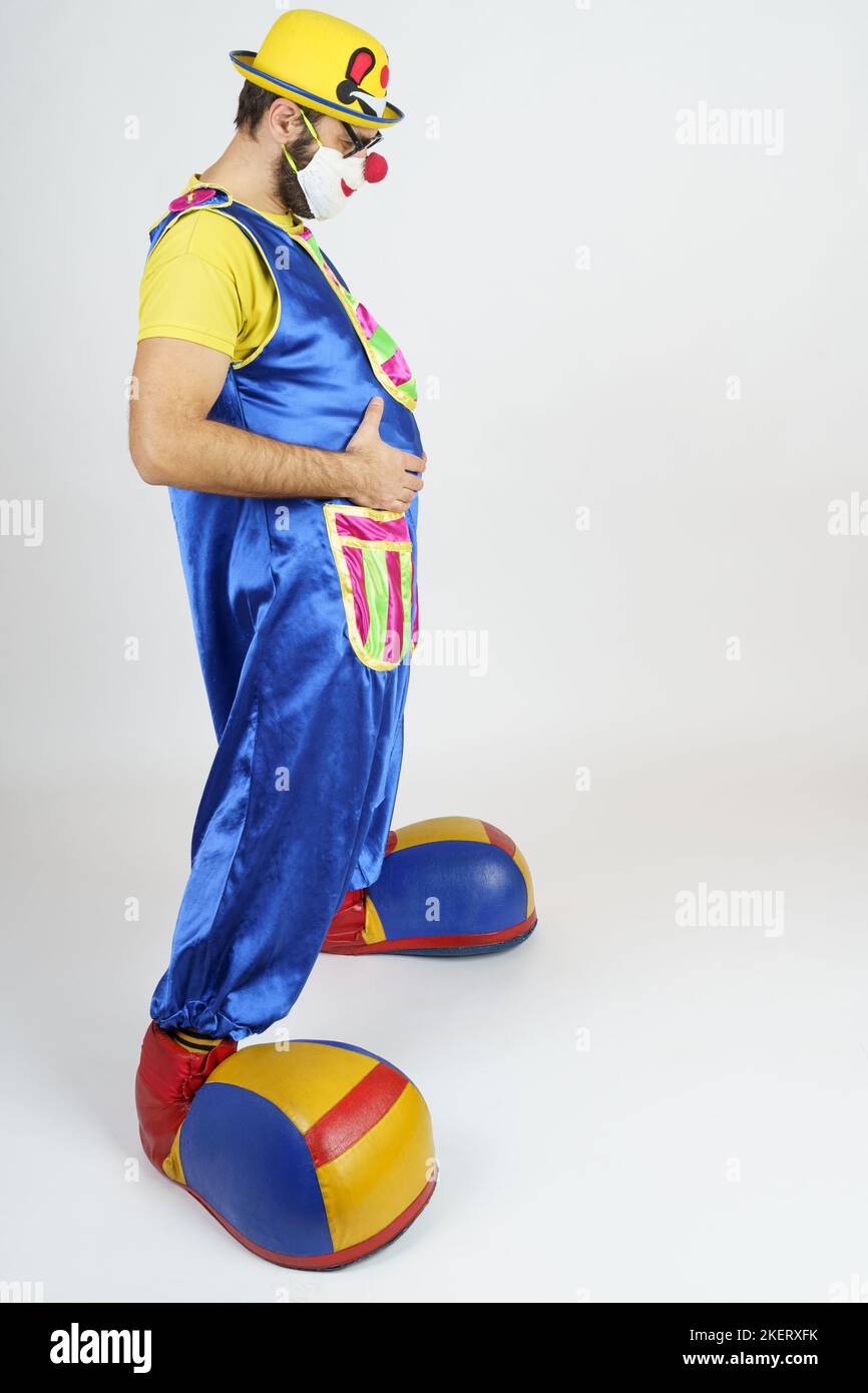 Holiday concept. The clown is a man in a bright blue and yellow suit ...