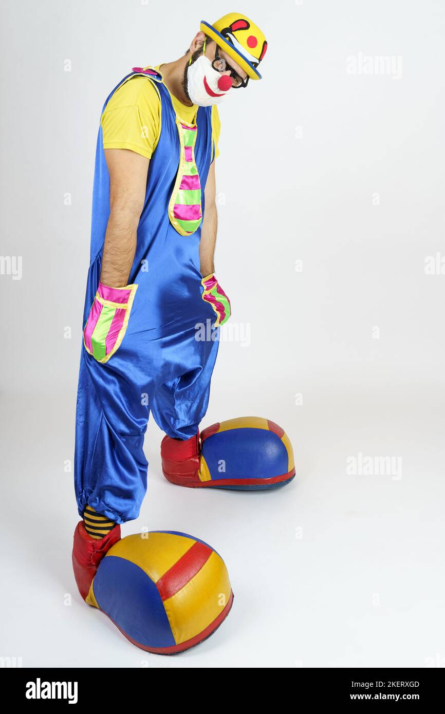 Holiday concept. The clown is a man in a bright blue and yellow suit ...