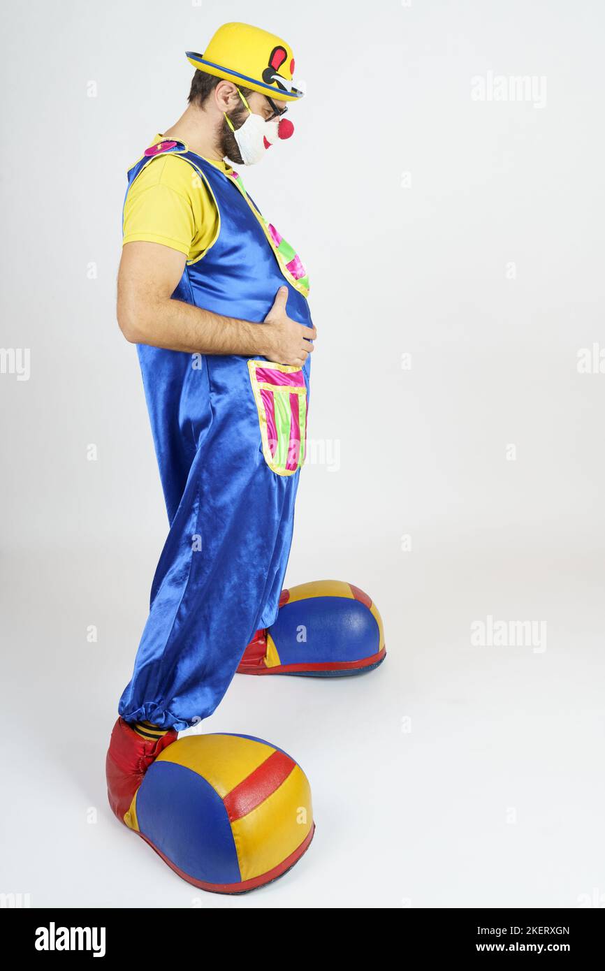 Holiday concept. The clown is a man in a bright blue and yellow suit ...