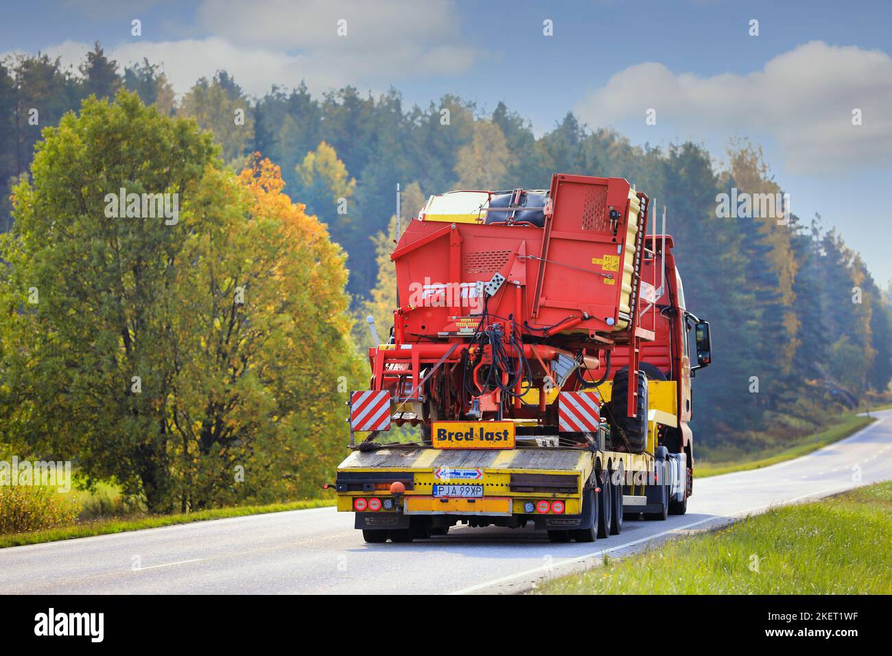 MAN truck of Mateo Transport hauls Grimme SE 75-30 potato harvester on road on a beautiful day of autumn, rear view. Salo, Finland. Sept 25, 20. Stock Photo