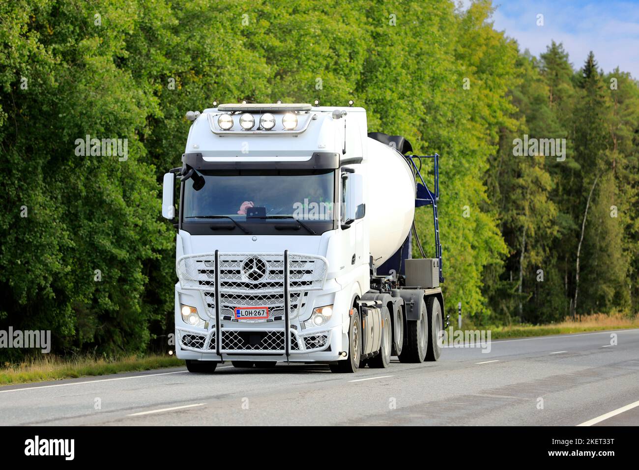 White Mercedes-Benz Actros 2853 concrete mixer truck at speed on highway, high beams briefly on. Marttila, Finland. September 11, 2020. Stock Photo