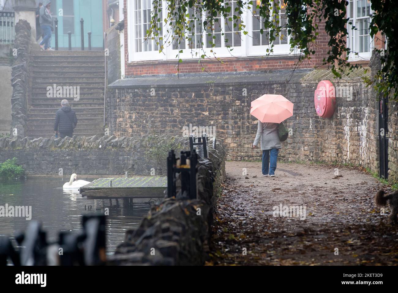 Windsor, Berkshire, UK. 14th November, 2022. A lady walks along Jennings Wharft next to the River Thames. After a beautiful sunny day yesterday, it was a foggy morning in Windsor, Berkshire. A yellow weather warning for fog was issued by the Met Office until 10am this morning. Credit: Maureen McLean/Alamy Live News Stock Photo