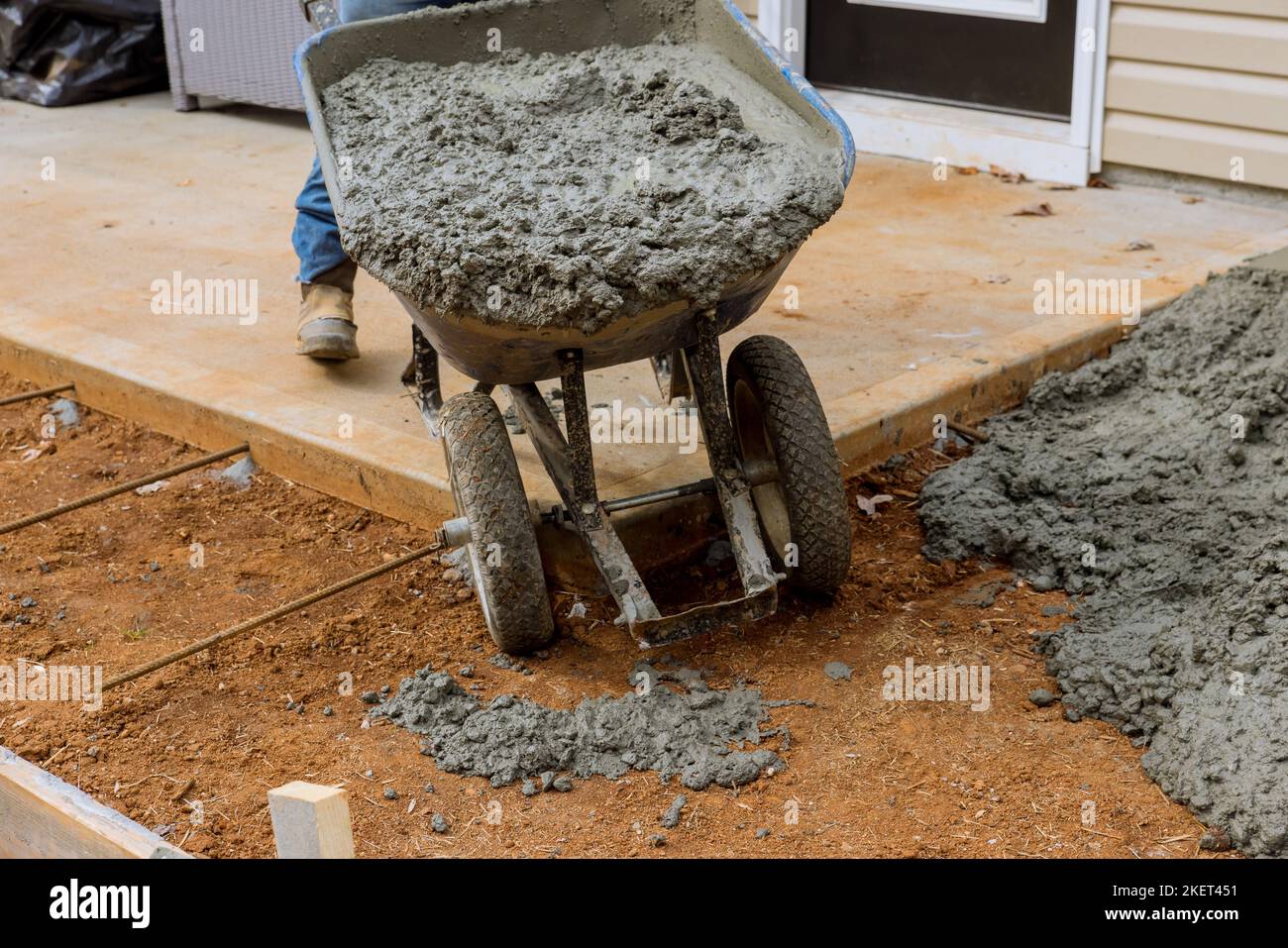Construction worker pours cement concrete sidewalk created on side of