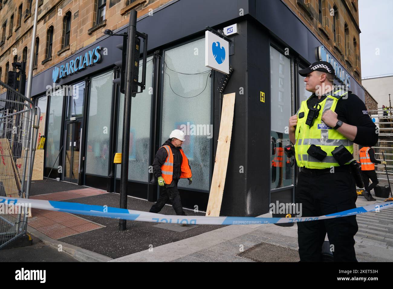 Workmen repairs windows at Barclays Clyde Place Quay branch in Glasgow, after they were broken by members from Extinction Rebellion Scotland as they demand Barclays cut its ties with fossil fuel firms. The protest is part of Extinction Rebellion and Money Rebellion's UK-wide Better without Barclays campaign of disruption. Picture date: Monday November 14, 2022. Stock Photo