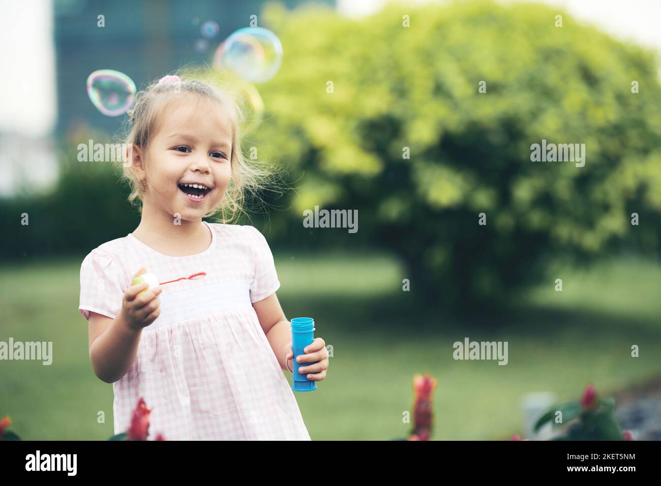 Little girl having fun and blowing soap bubbles Stock Photo - Alamy