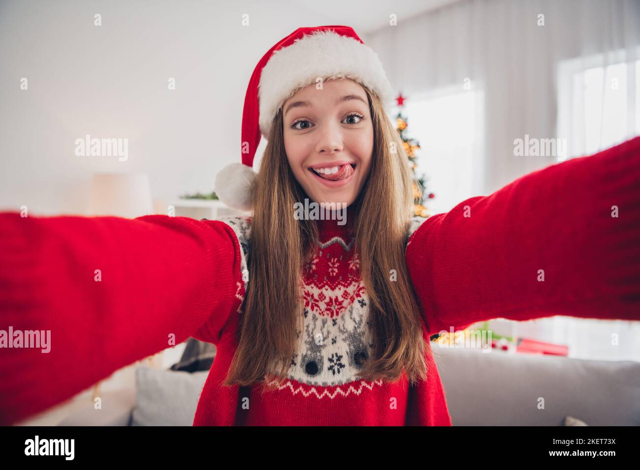 Photo of funky cheerful girl take selfie tongue lick teeth beaming smile festive christmastime indoors Stock Photo