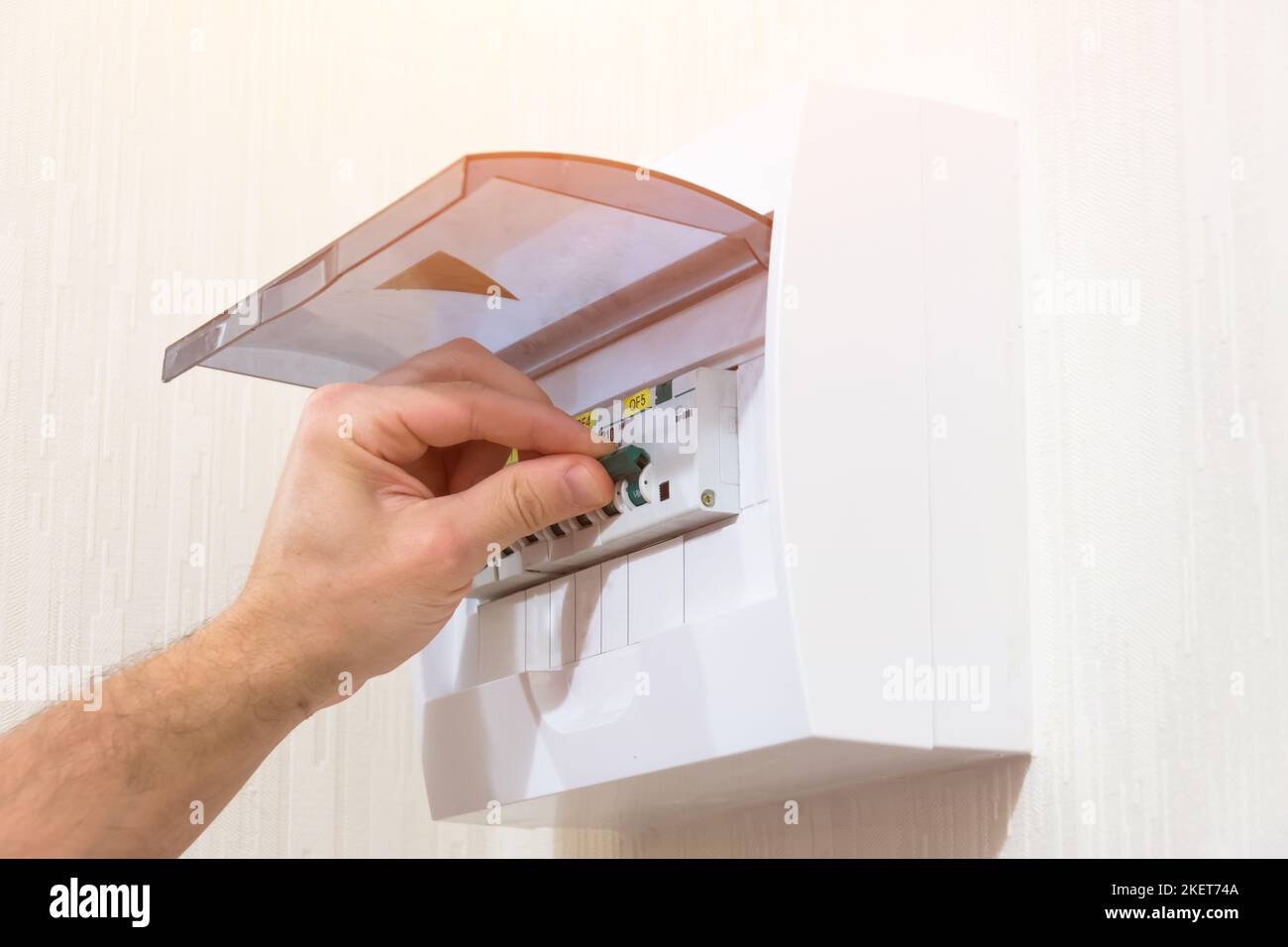 Circuit breaker board displays many switches. A finger is about to turn