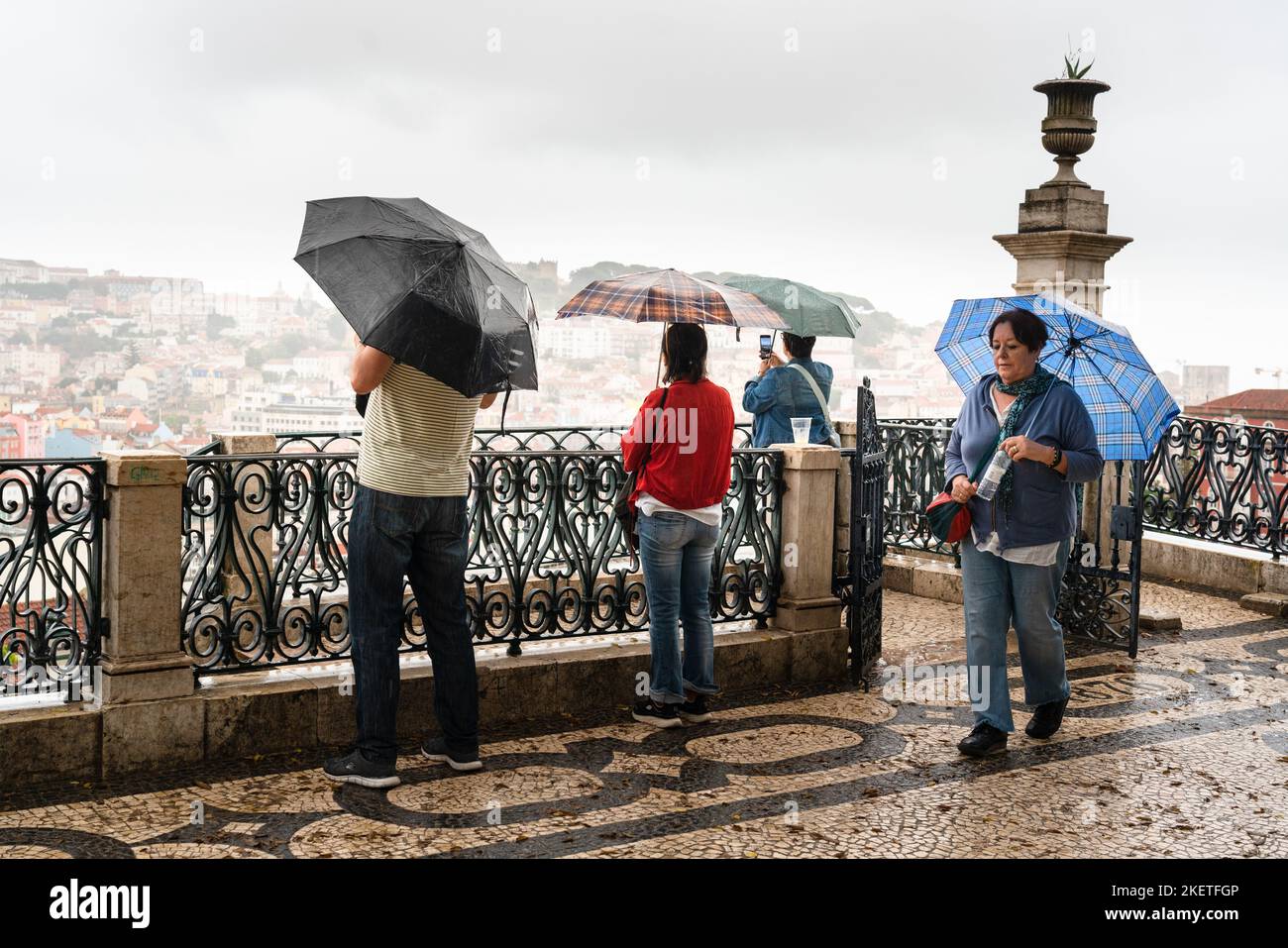 Heavy rain sweeps in obscuring parts of the city at the Miradouro de São Pedro de Alcântara in Lisbon, Portugal. Stock Photo
