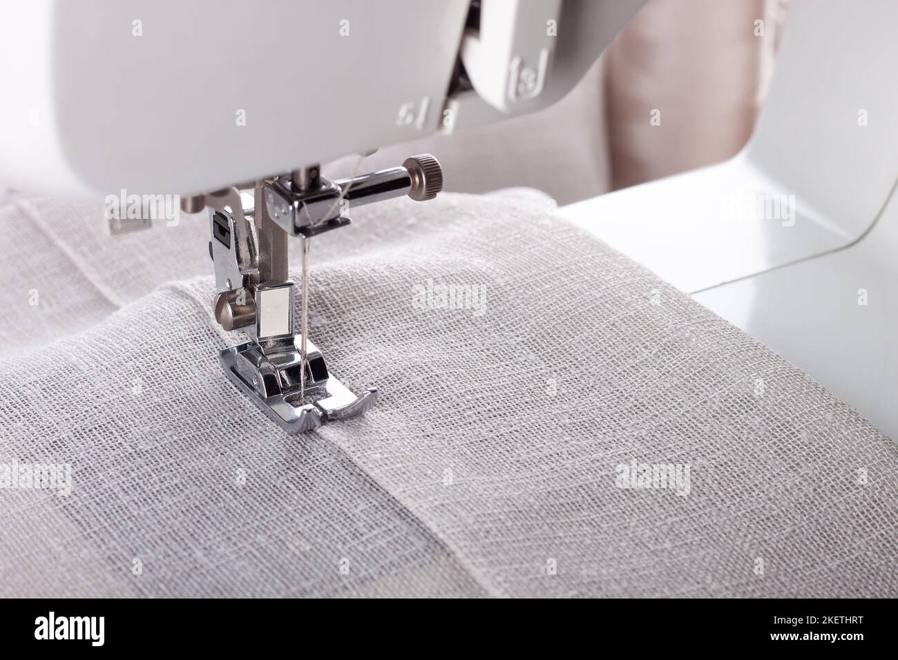 Modern sewing machine presser foot with linen fabric and thread ...
