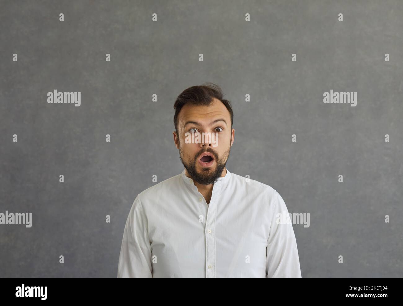 Caucasian man with a surprised and shocked expression is stunned by unexpected news or information. Stock Photo
