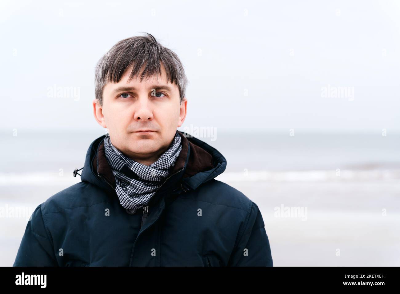 Portrait of a serious relaxed middle-aged man near the winter sea Stock Photo