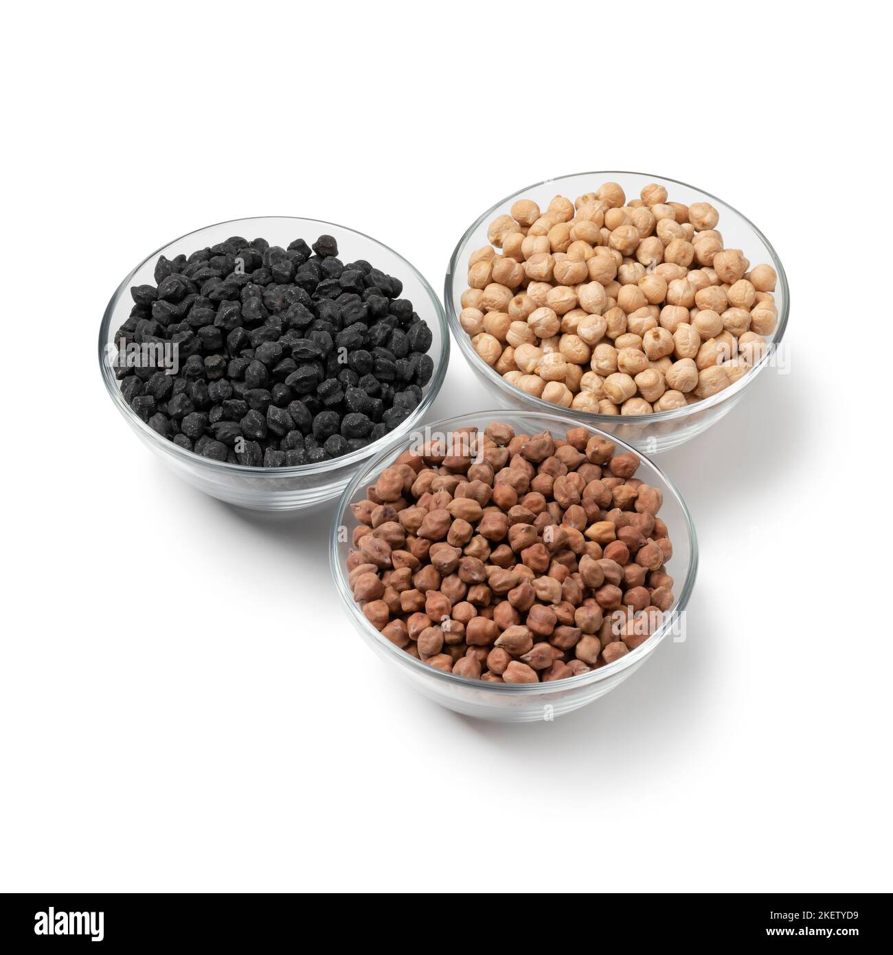 White medterranean garbanzo, black Italian ceci neri and brown indian Kala Chana chickpeas in a glass bowl isolated on white background Stock Photo