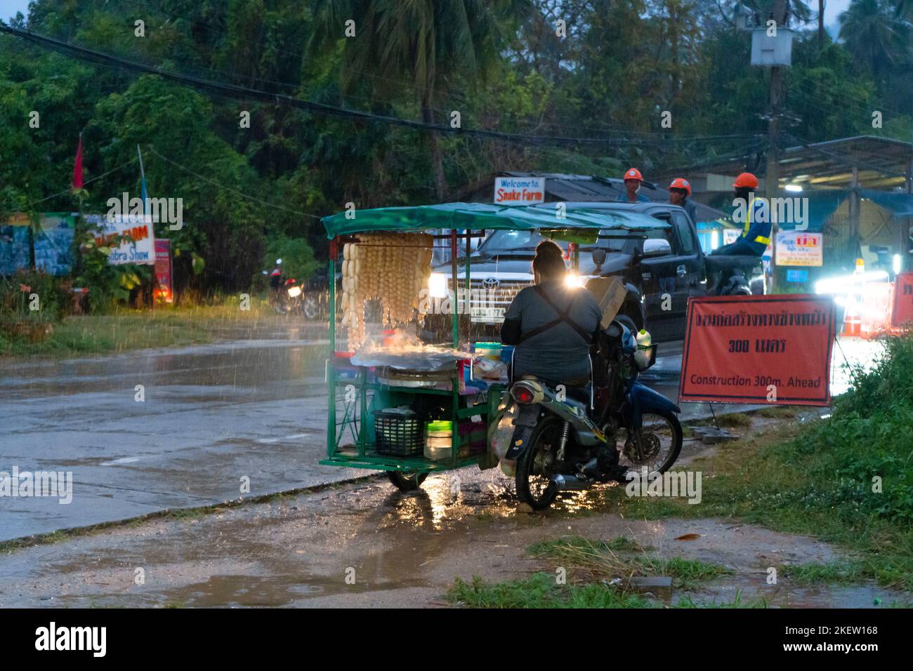 A snack vendor on a bike selling food in the rain. Samui, Thailand - 02 ...