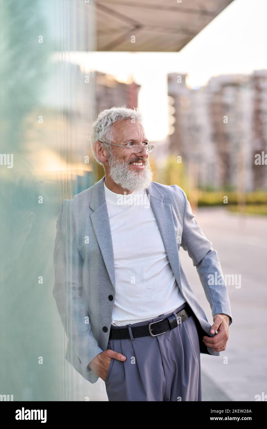 Stylish happy senior old business man wearing suit standing outdoor, portrait. Stock Photo