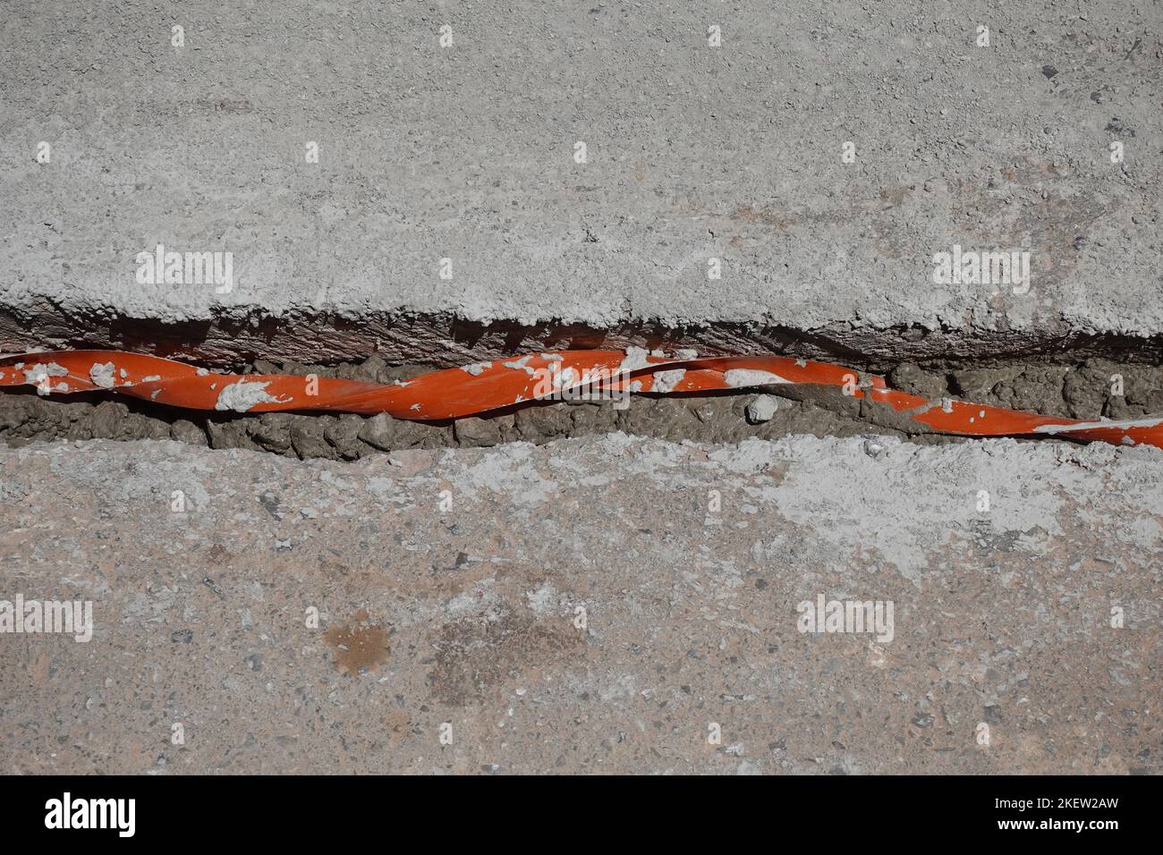 Cable insulation for underground wires passing through trench under street concrete. Undergrounding electric lines. Stock Photo
