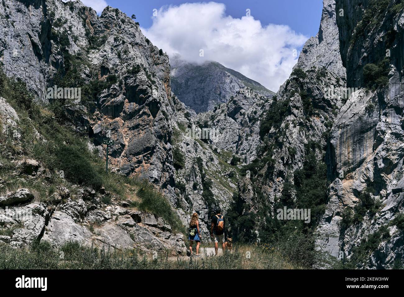 Path Between The Rocks blonde caucasian girl in sportswear and caucasian boy with backpack ...