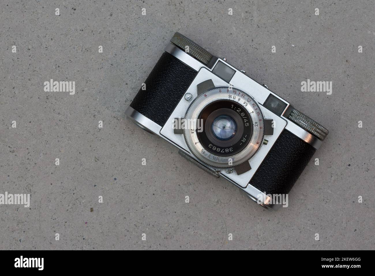 Old photo cameras from the 1950s lie on a concrete floor. Stock Photo