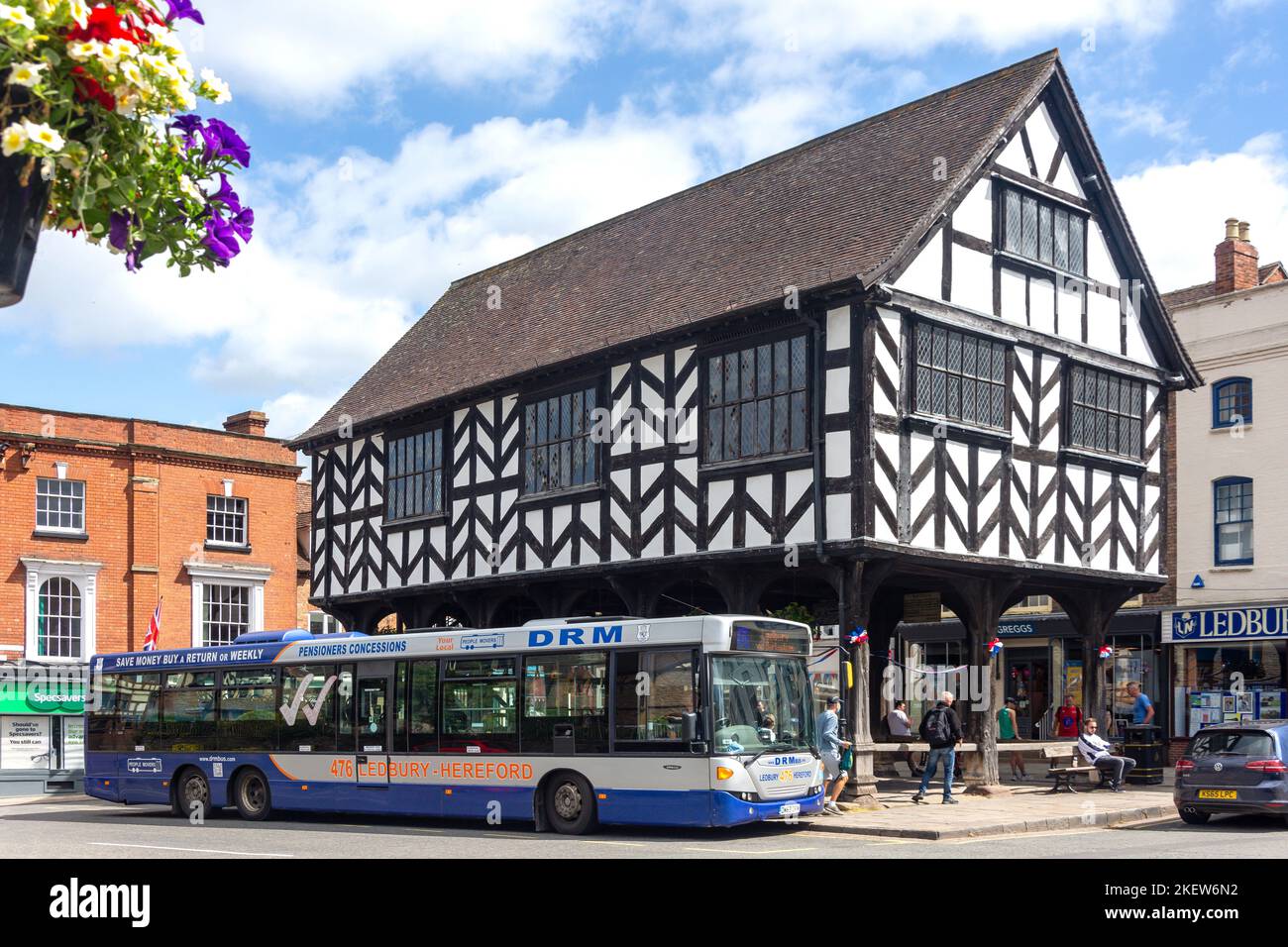 Local bus at bus stop by 17th century Market House, Market Place, High