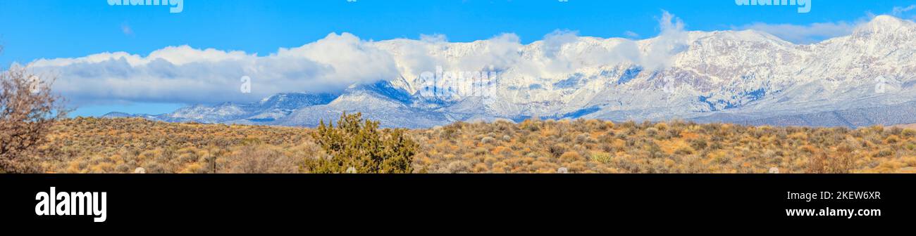 Panoramaaufnahme aus der Wüste von Nevada im Winter mit grandiosem Fernblick auf schneebedeckte Berge bei wolkenlosem Himmel fotogrfiert in den USA im Stock Photo
