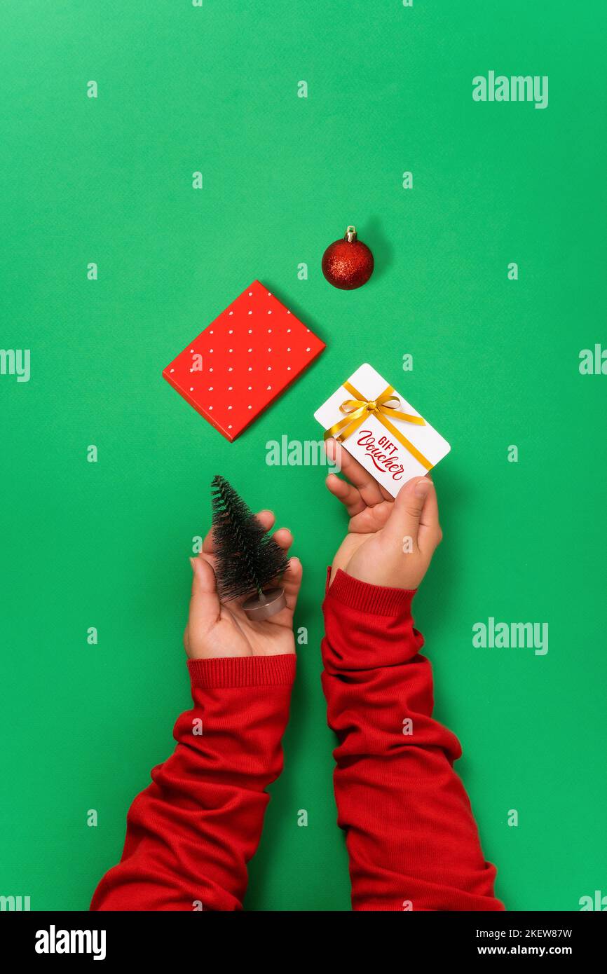 Women's hands hold a gift voucher, a card in hand for online shopping christmas gifts background