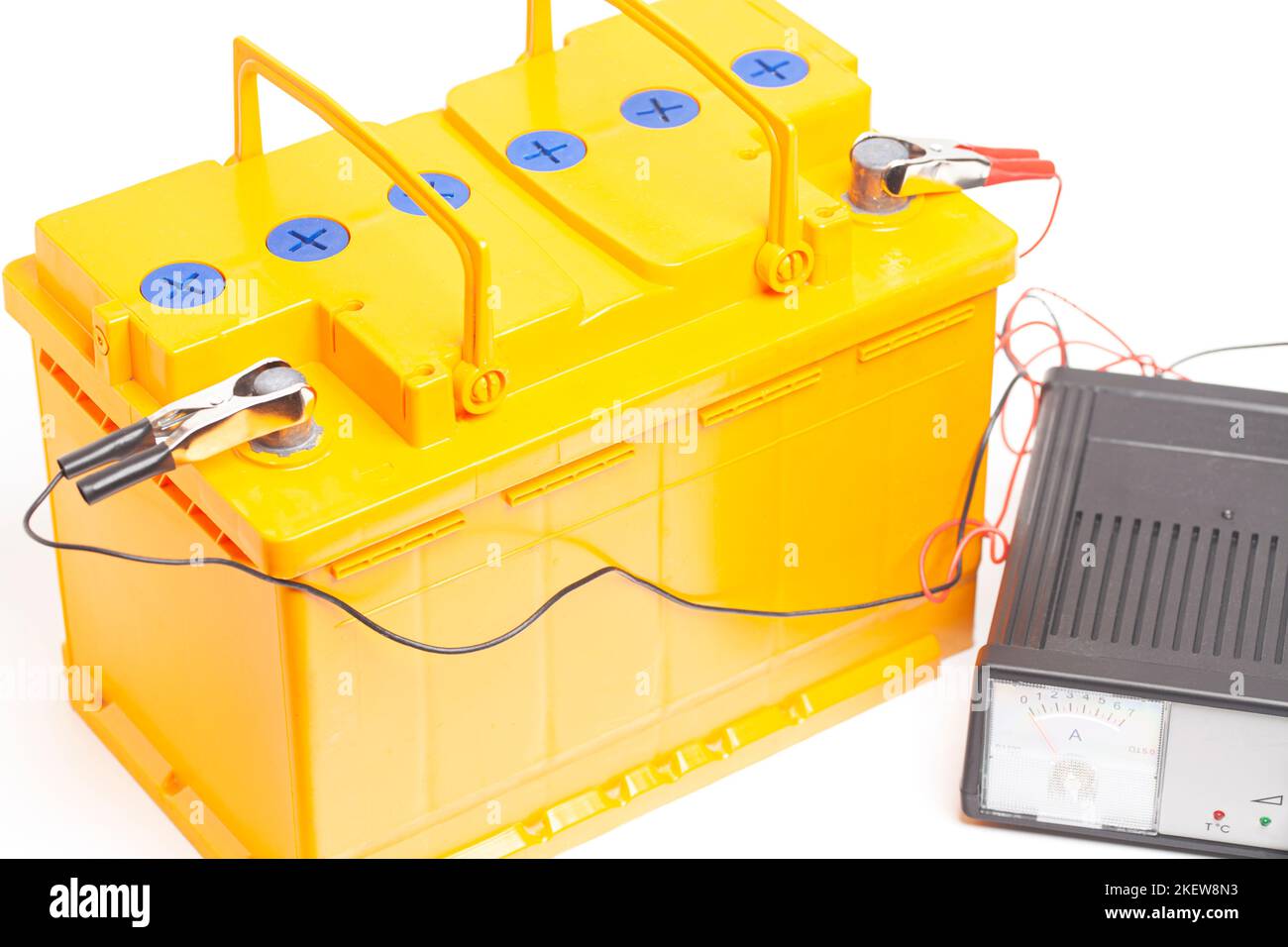 yellow car battery with car battery charger isolated on white