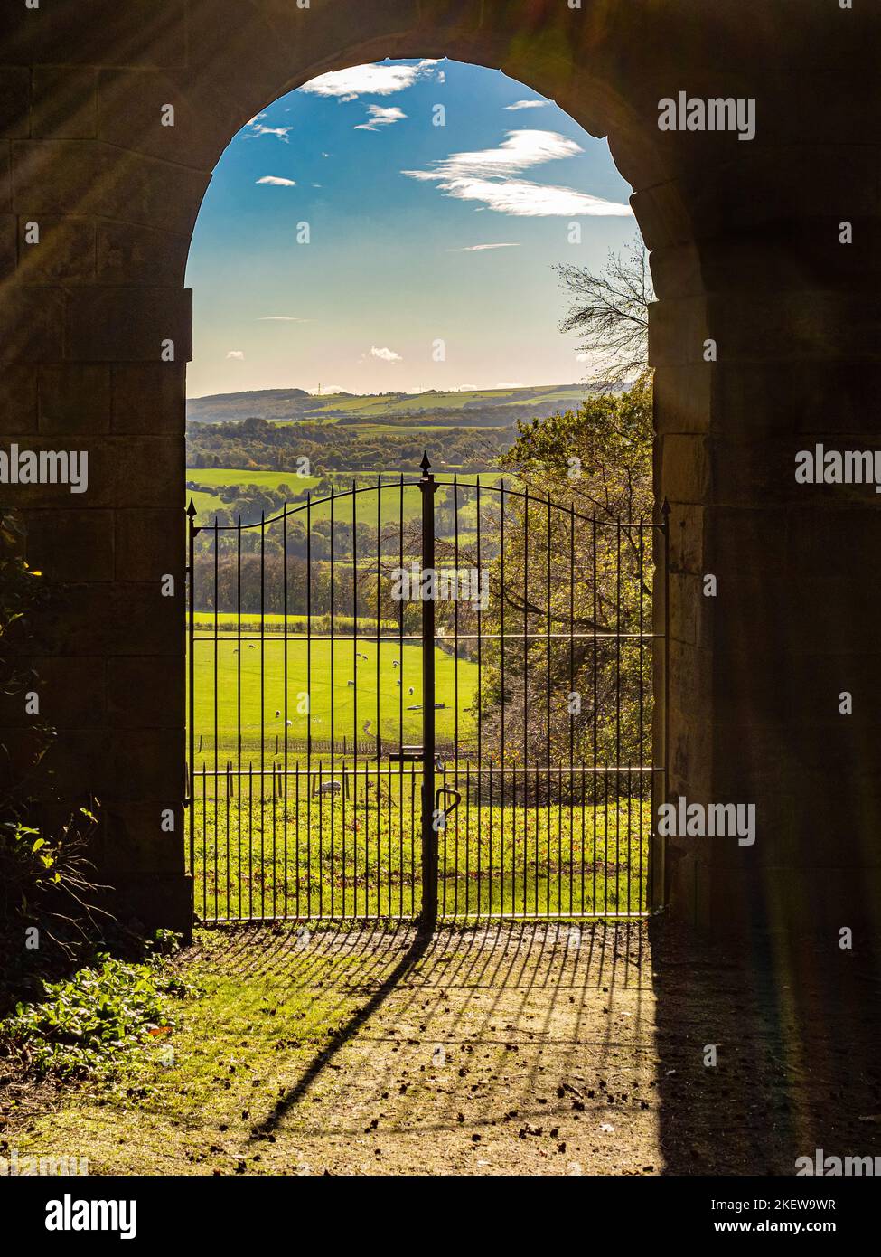 Looking out through one of the arches of the Archer's Hill Gate towards the parkland of Wentworth Castle Gardens. UK Stock Photo