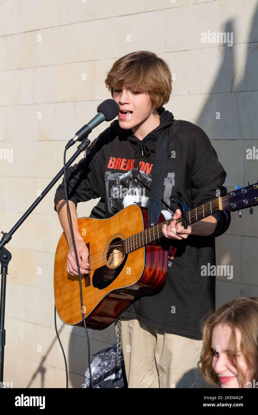 Bender, Moldova - November 12, 2022: Guy playing guitar on street and