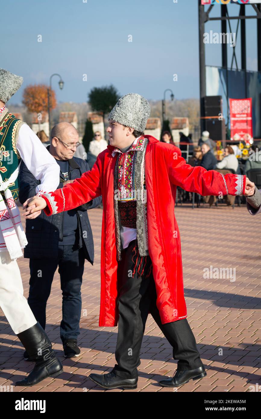Bendery, Moldova - November 12, 2022: People dance Moldovan dance. Men and women in national costumes dance the beautiful Moldavian chora dance on eve Stock Photo