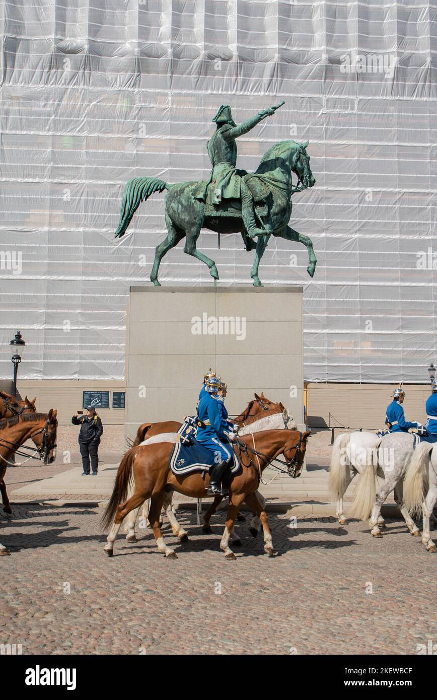 Royal Guards on horseback ride past Charles XIV John's statue (Karl XIV Johans ryttarstaty