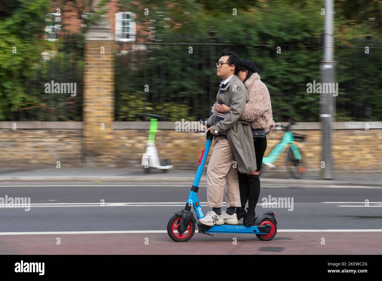 A couple riding on a Dott escooter part of the Transport for London e