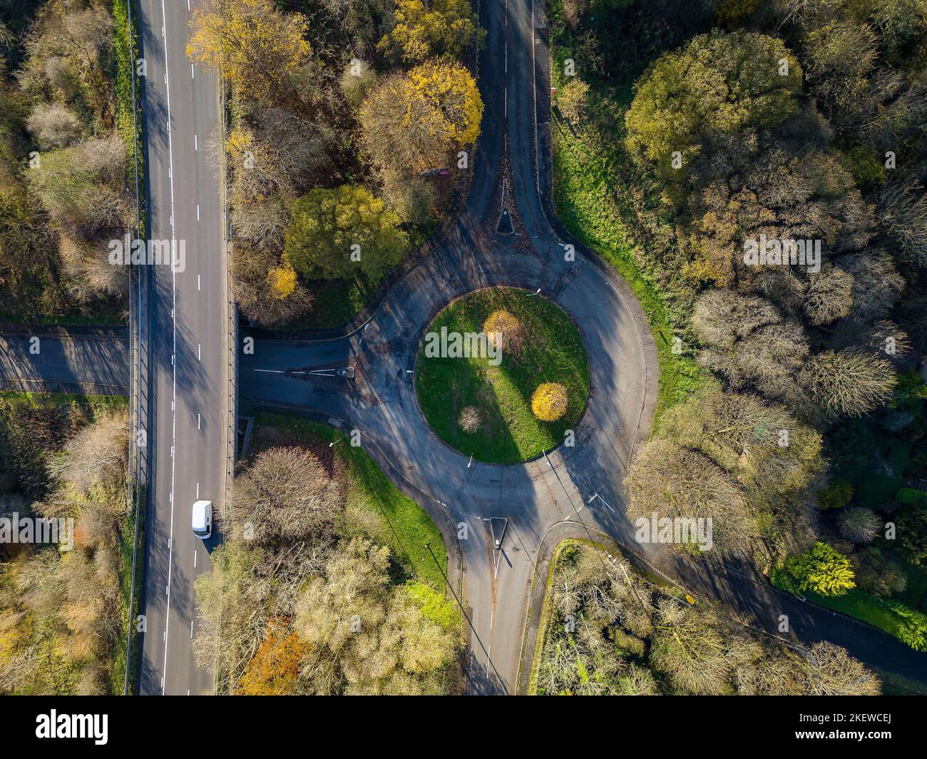 A small traffic roundabout surrounded by beautiful autumn coloured leaves (Wales) Stock Photo