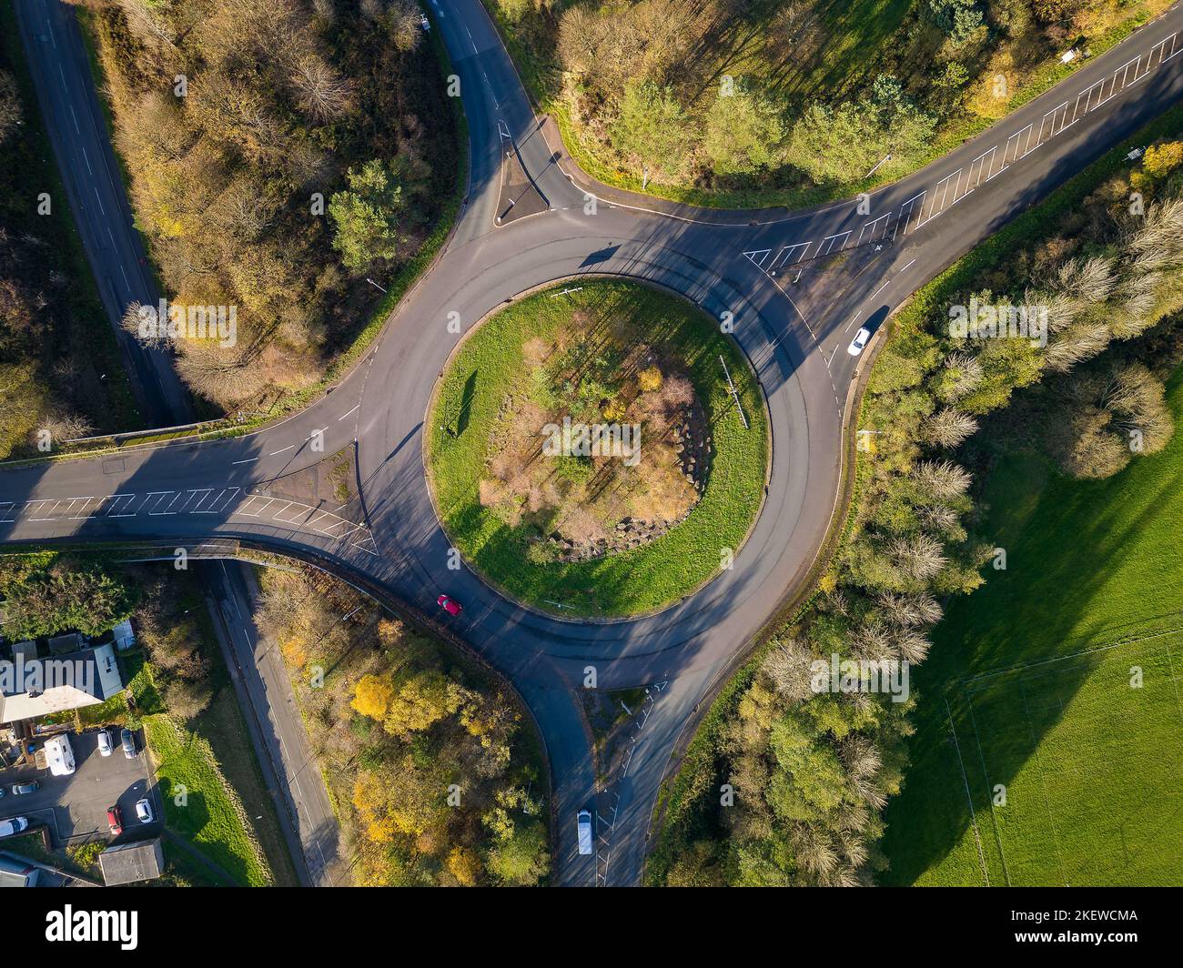 A small traffic roundabout surrounded by beautiful autumn coloured leaves (Wales) Stock Photo