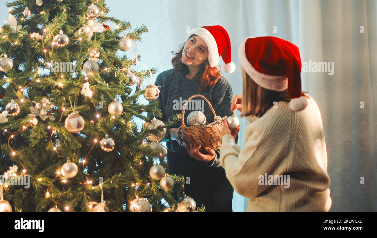 Happy girls prepare Christmas tree Stock Photo Alamy