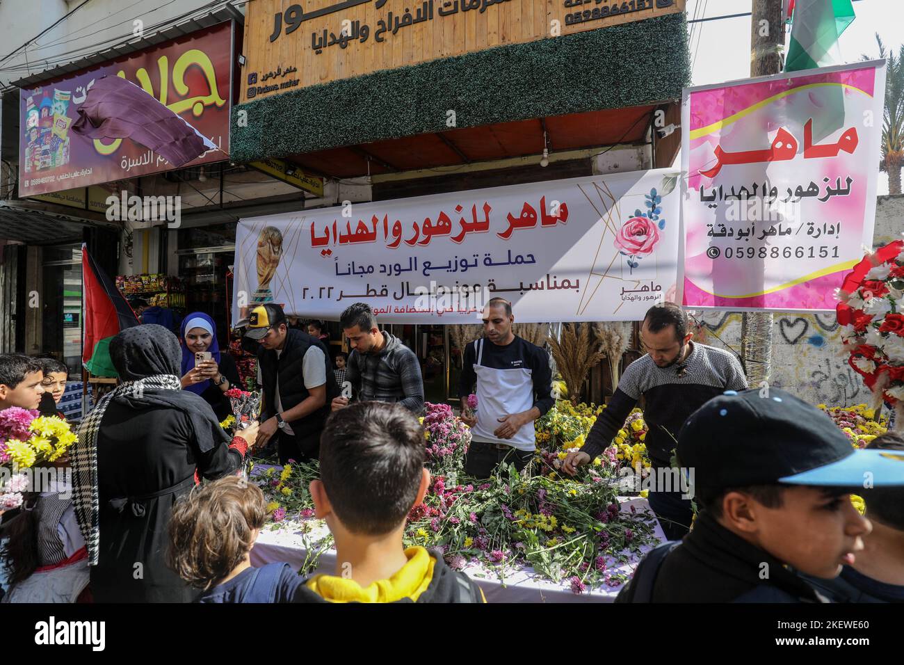 Palestinians in a flower shop distribute flowers to passersby, to