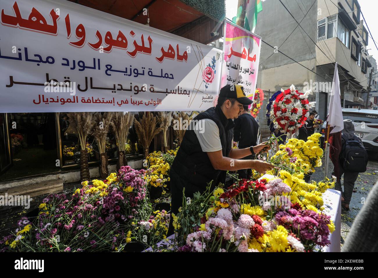 Palestinians in a flower shop distribute flowers to passersby, to