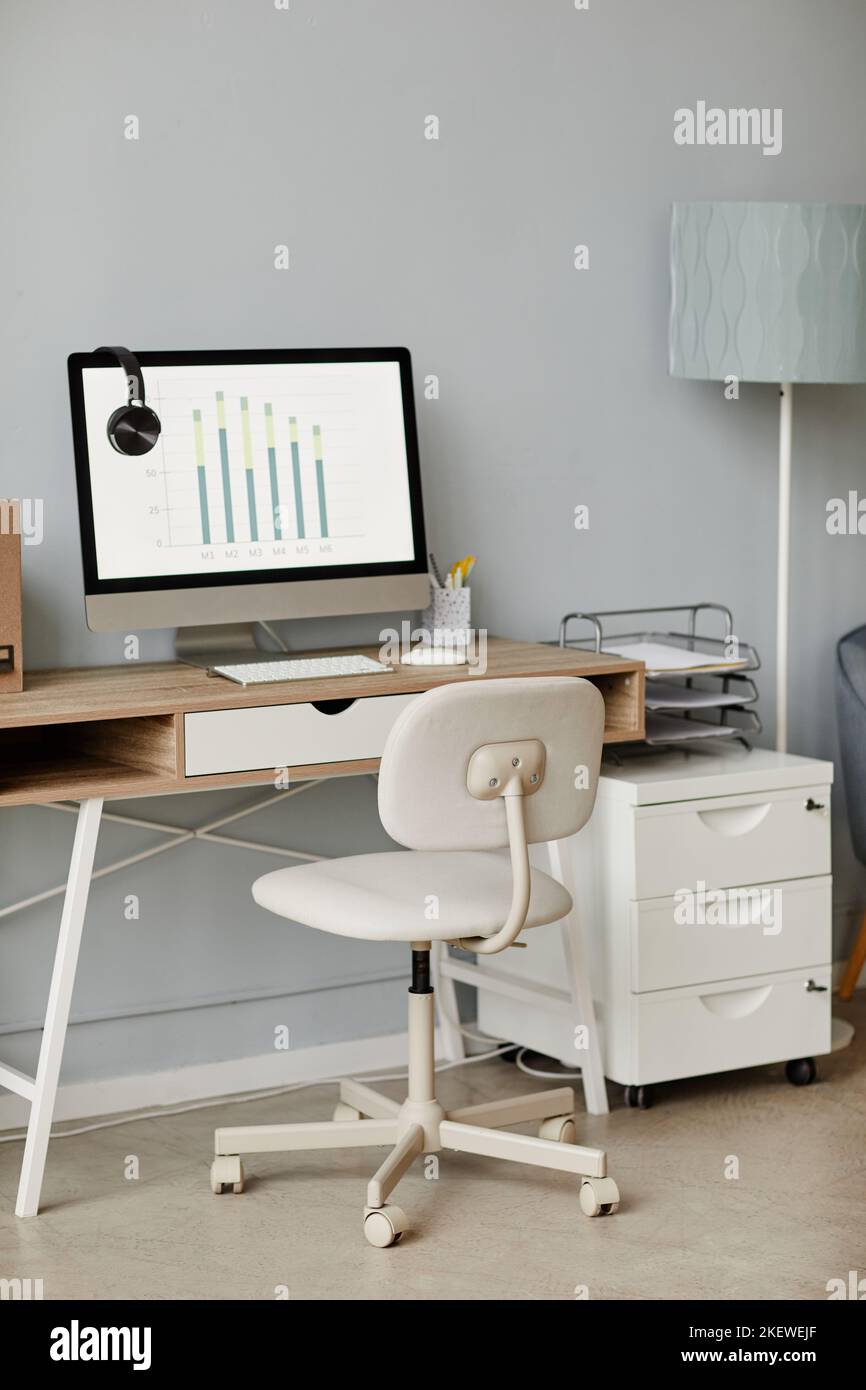 Vertical background image of minimal home office workplace in white with computer on wooden desk, copy space Stock Photo
