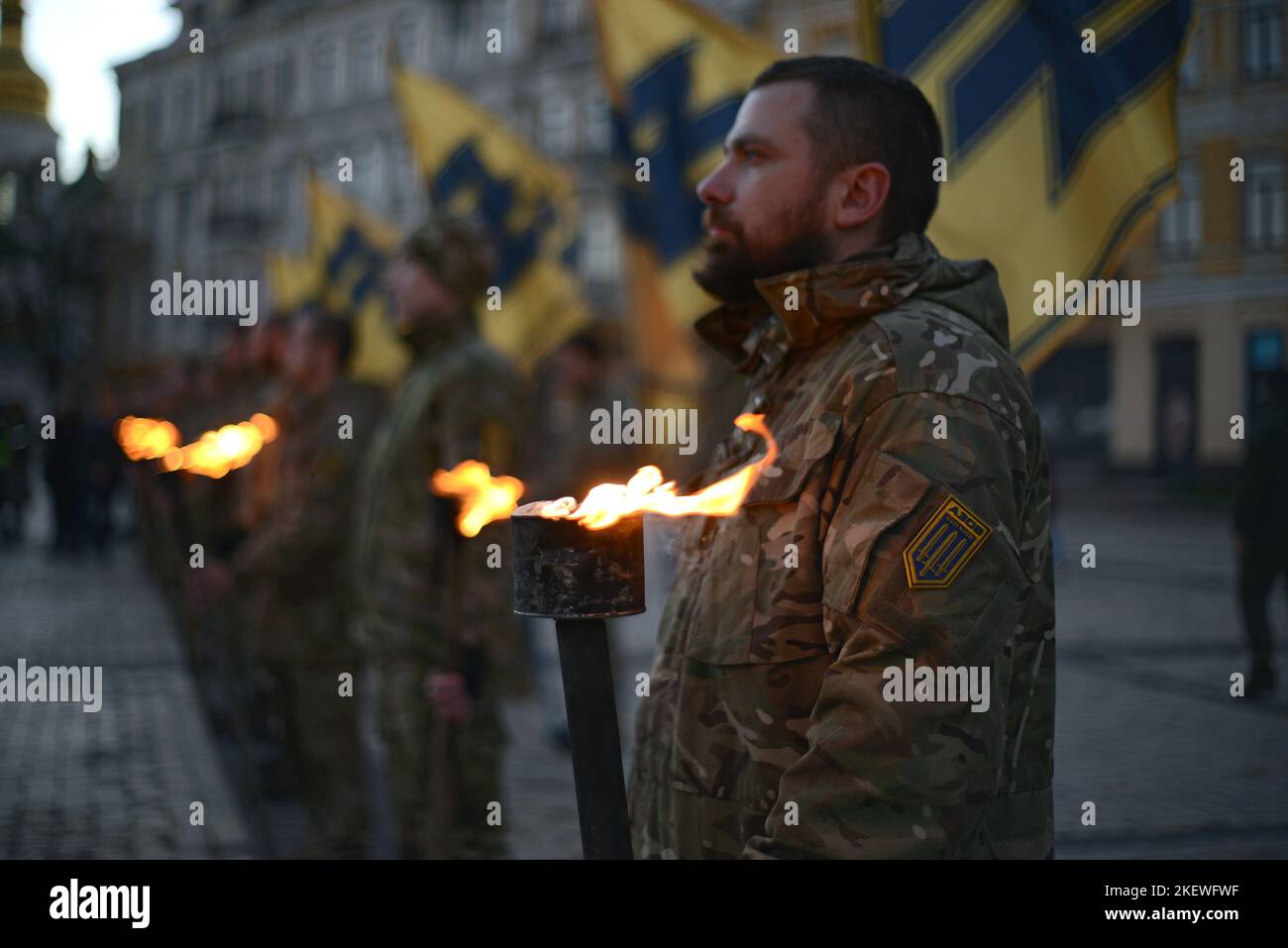 KYIV, UKRAINE - NOVEMBER 13, 2022 - Soldiers of Azov regiment hold burning torches to commemorate their fallen brothers in arms during the Heavenly Regiment of Azov mystery in Sofiyska Square, Kyiv, capital of Ukraine. Stock Photo